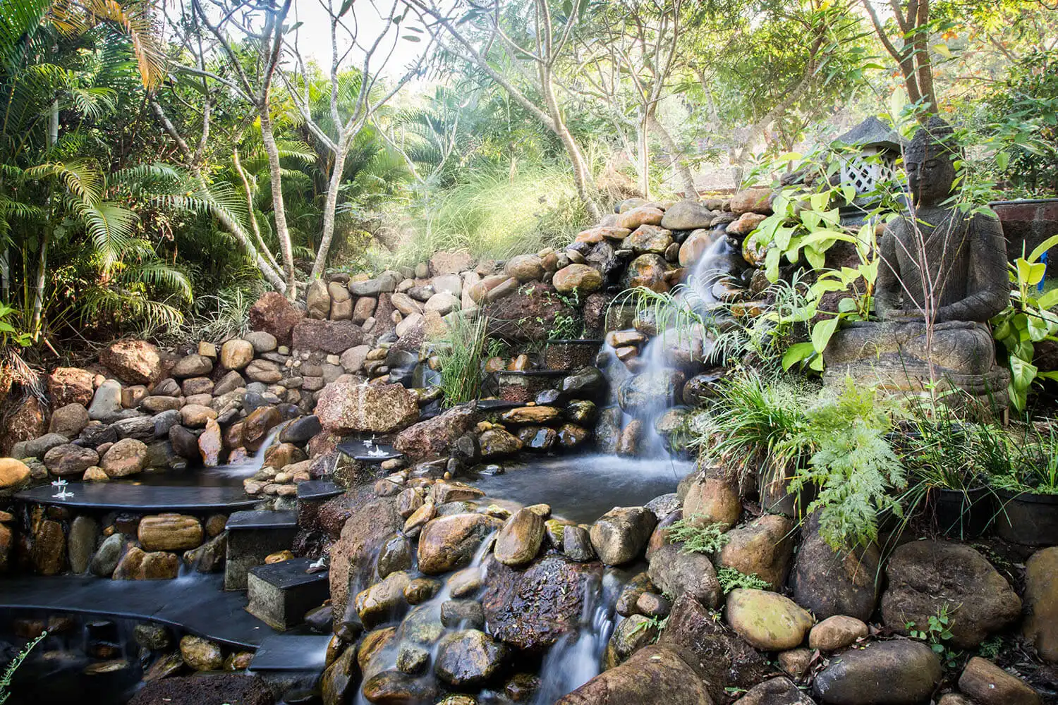 The waterfall with its Buddha